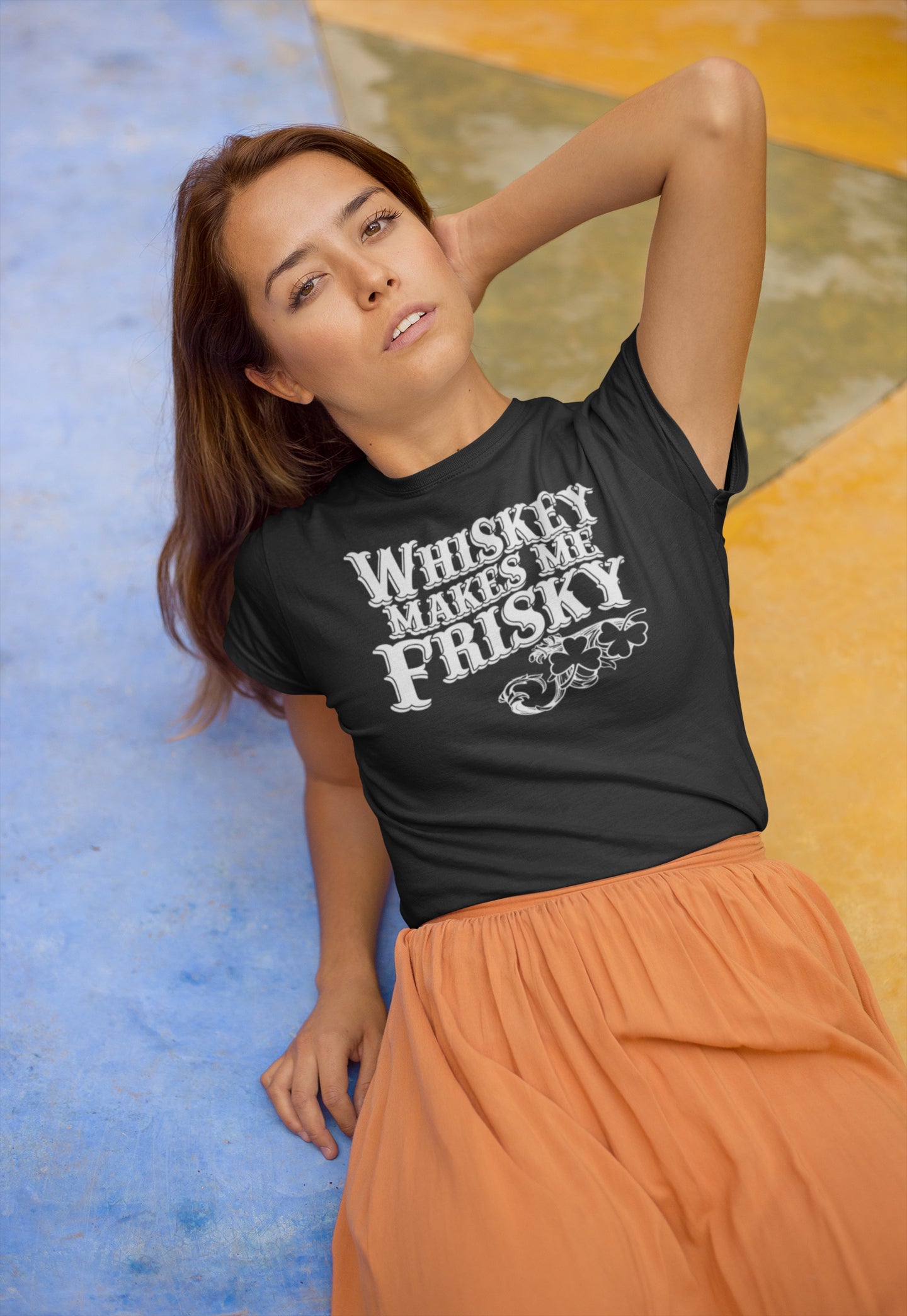 Front view of women’s t-shirt declaring Whiskey Makes Me Frisky in distressed white print