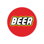 A round ceramic coaster featuring a colorful building block-inspired design, perfect for beer lovers.