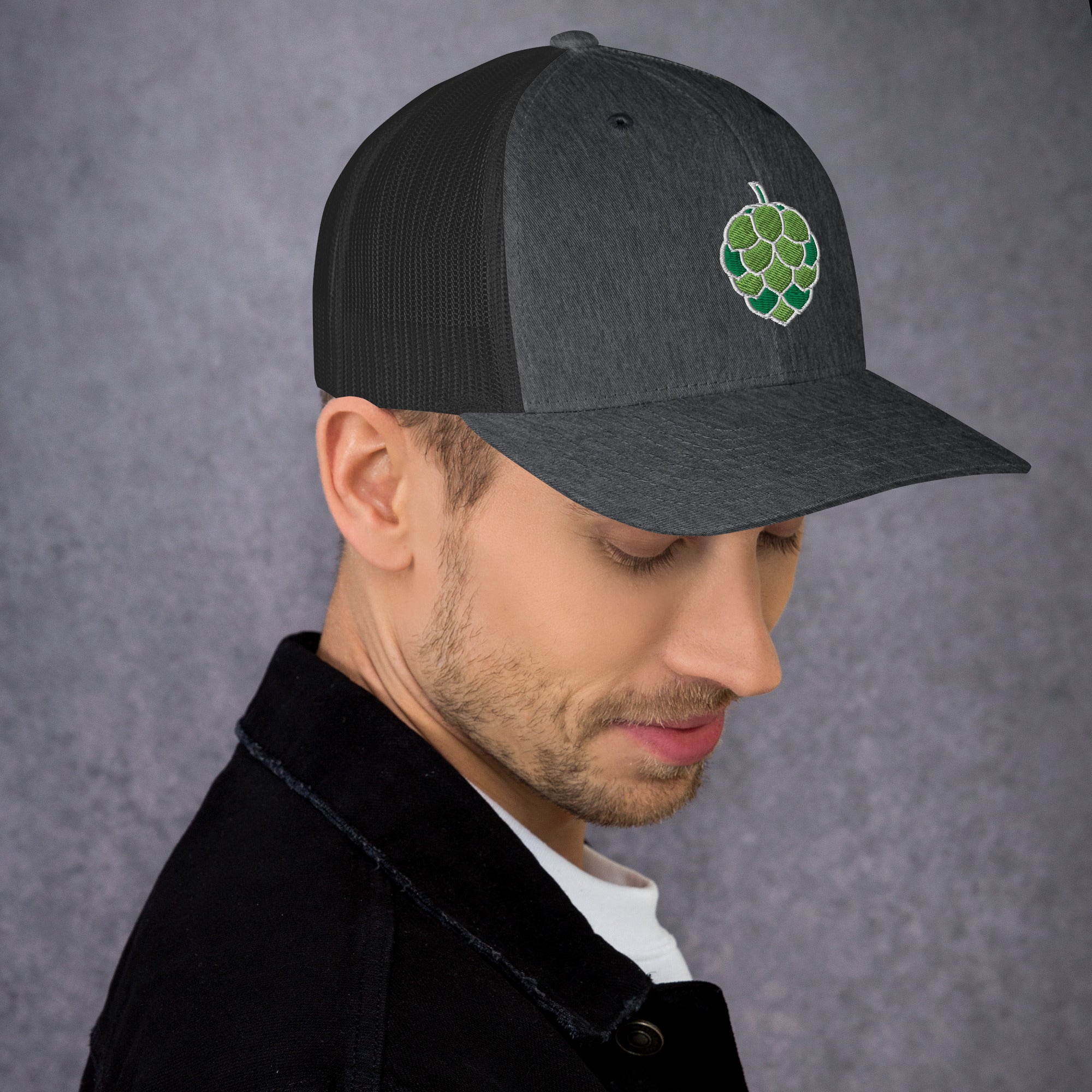 Side profile of charcoal trucker hat with embroidered beer logo